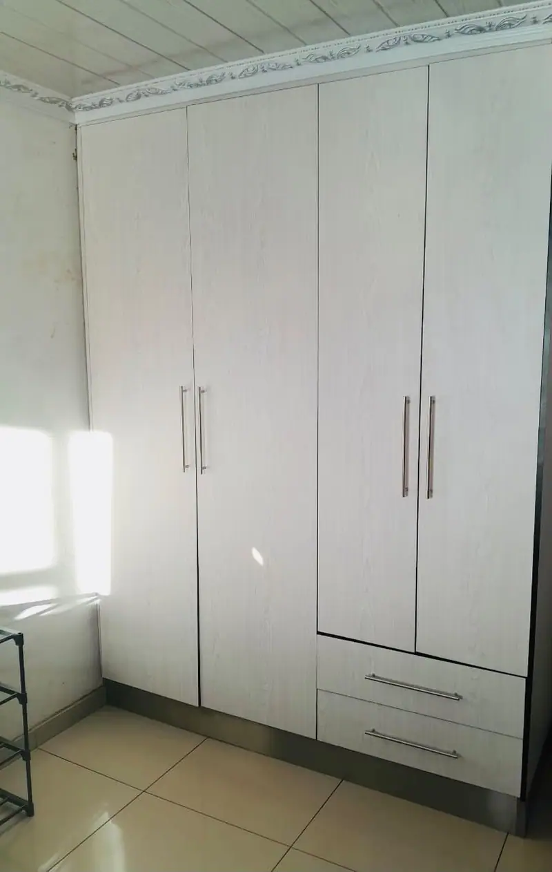 Fitted wardrobe with drawers beneath tall doors
