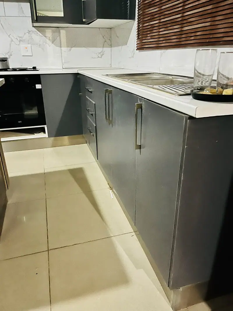 Charcoal base cabinets with drawers and a white worktop
