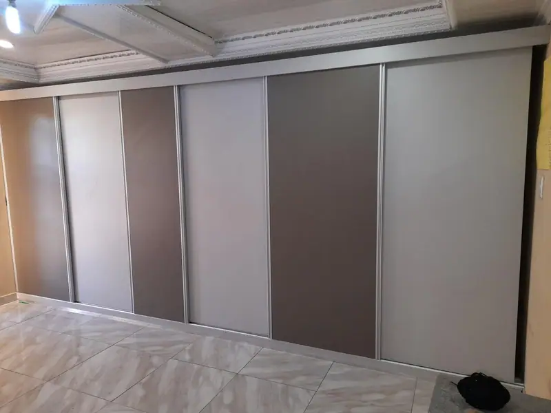 Sliding wardrobe doors in grey, taupe and white panels