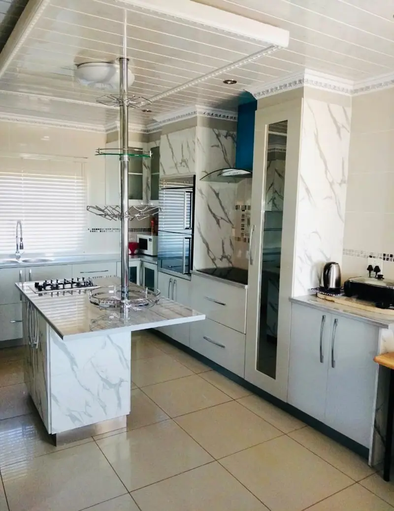 Marble-effect island with a built-in hob in a white kitchen