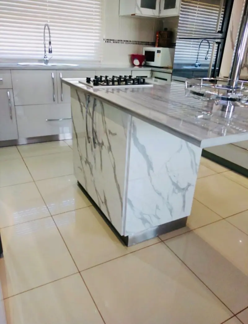 Marble-effect island in a tiled white kitchen