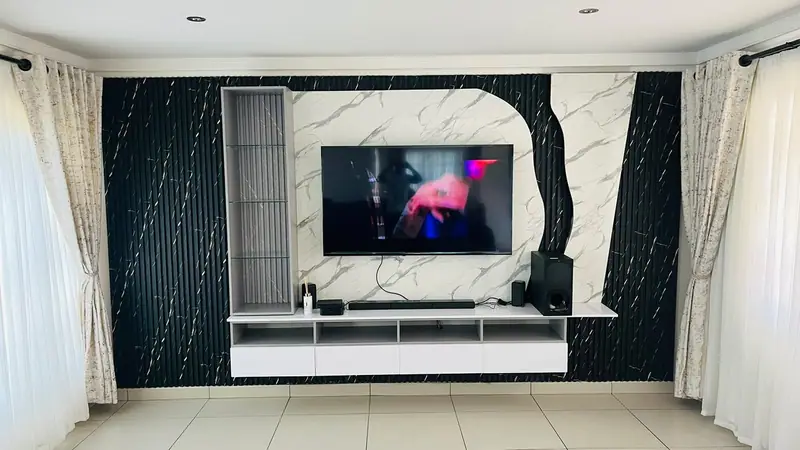 Floating white TV unit on a black and marble-effect feature wall