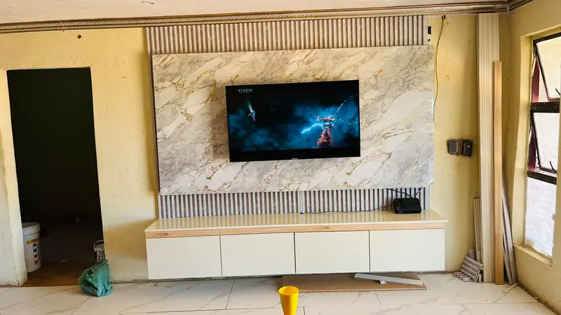 Floating TV unit on a marble-effect wall with timber slat panels