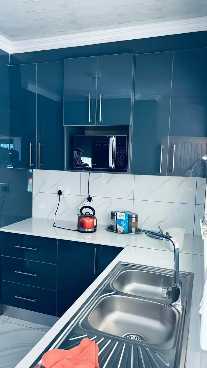 Navy gloss kitchen with a double sink and a white worktop