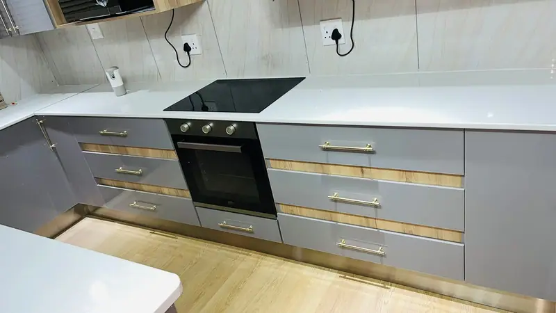 Grey base units with timber-accent drawers and a built-in oven