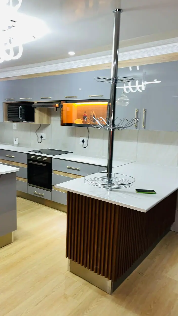 Kitchen island with fluted timber panelling under a ceiling light feature