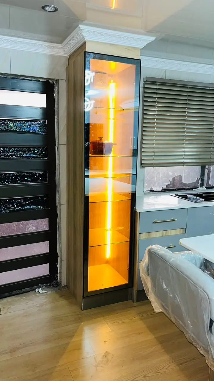 Tall glass display cabinet with warm internal LED lighting