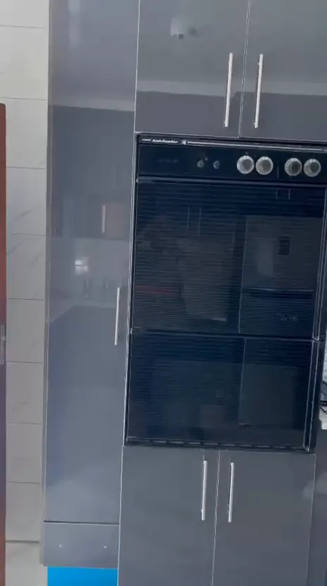 Still from a walk-through video of the navy and grey gloss kitchen
